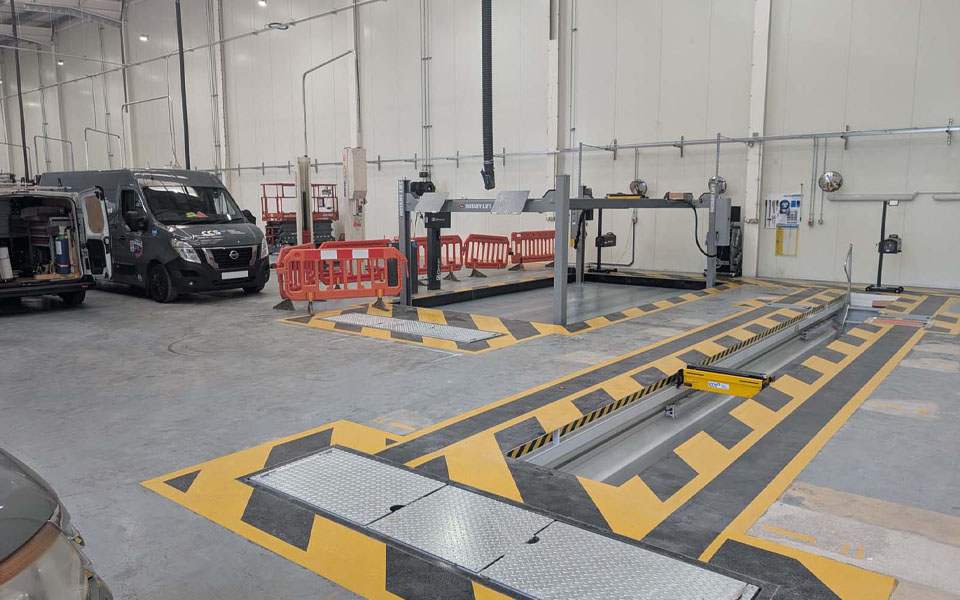 Adams Moreys vehicle workshop feautring a recessed MOT bay with black and yellow safety markings.