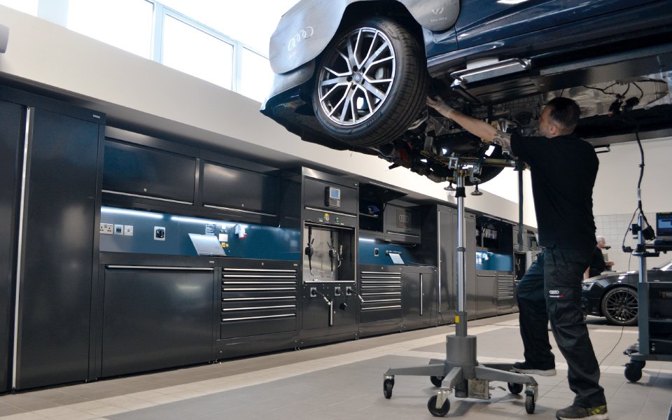 Engineer working under vehicle at Audi Farnborough vehicle workshop installed by CCS Garage Equipment