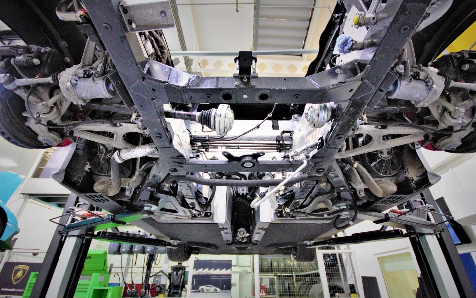 Car chassis on Nussbaum 2-post fixed vehicle lift at Lamborghini dealership workshop in London