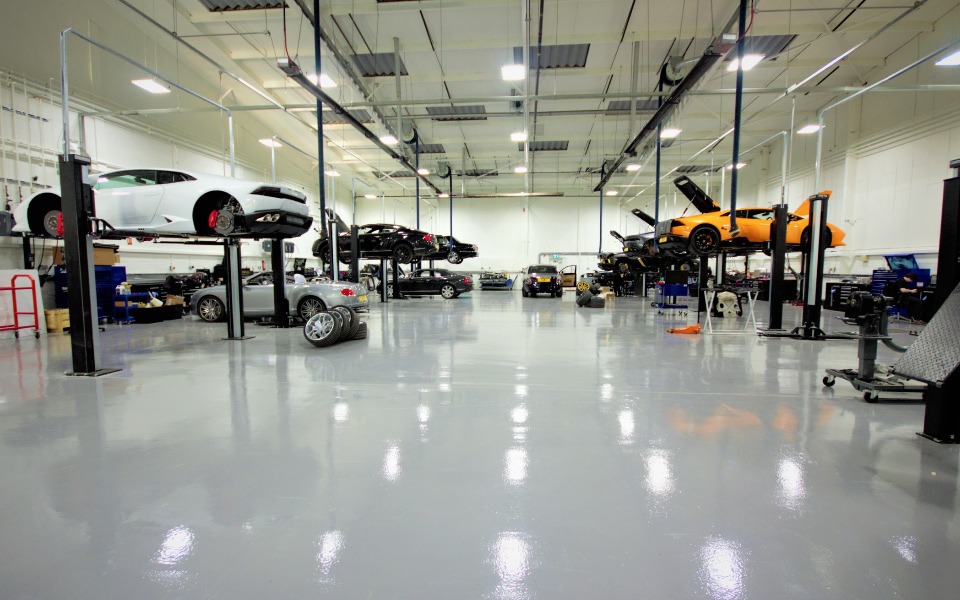 Completed new-build garage equipment installation with spacious work areas around each vehicle designed by CCS for Lamborghini’s dealership in London
