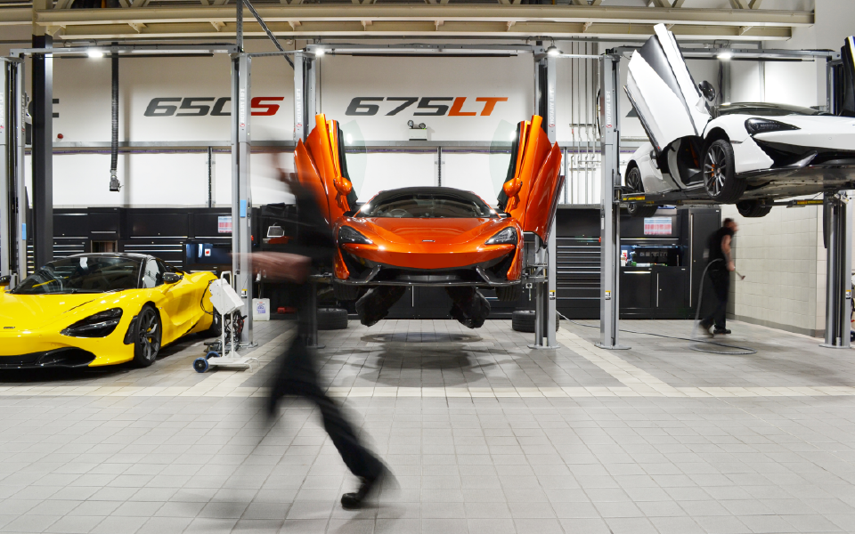Vehicles lifted during maintenance at McLaren Ascot, using fixed 2-post Rotary lifts in spacious workshop bays designed by CCS as part of our garage equipment installation project for the dealership