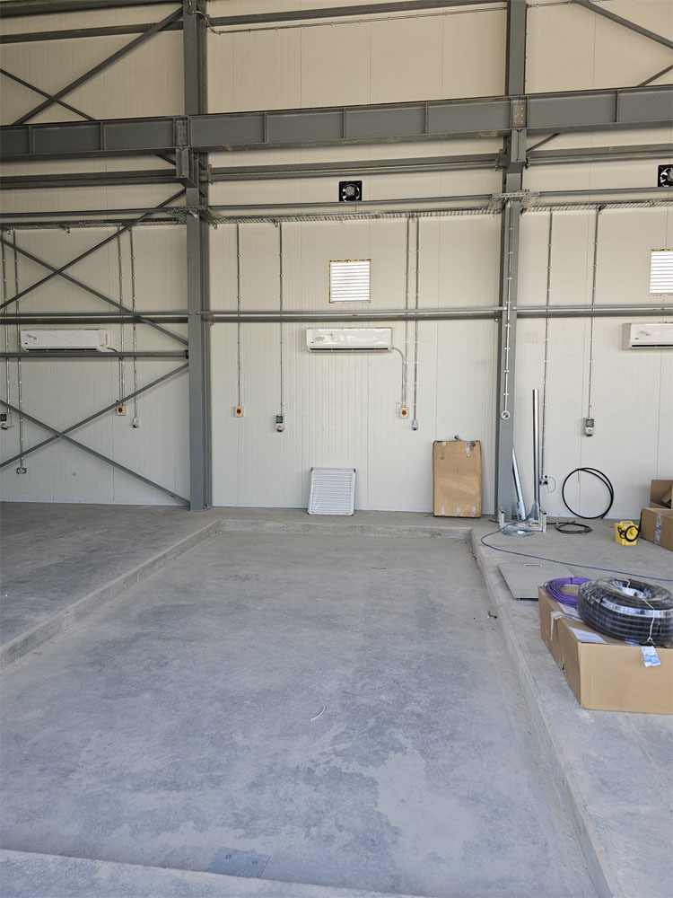 Concreate floor recessed for new 4-post vehicle lift inside of new military vehicle workshop.