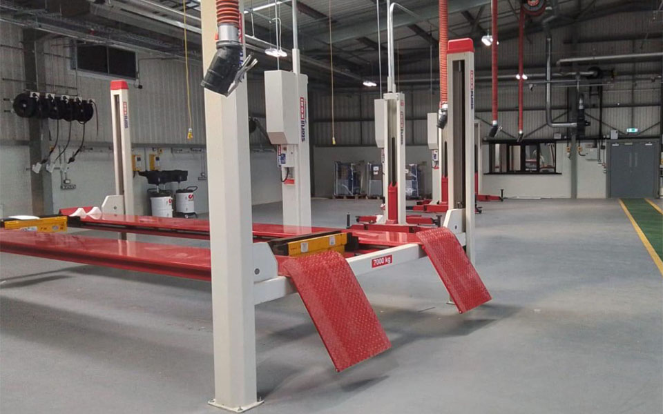 Red Stertil Koni Four-Post Lift inside of new workshop depot for NWAS Cumbria.
