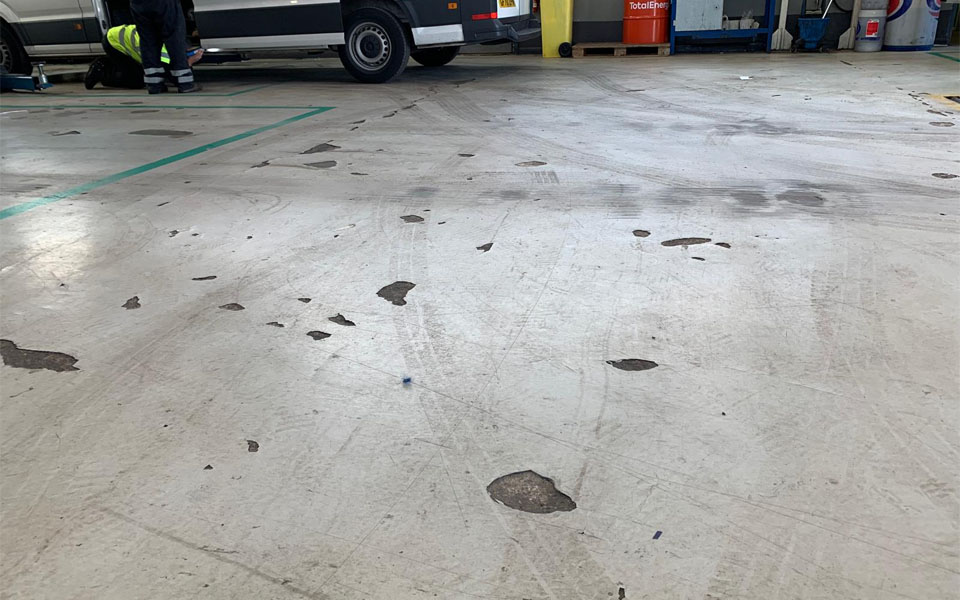Old workshop floor worn with weak spots and gaps