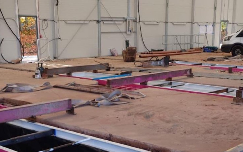 Photo shows installation of 3 steel inspection pits for garage workshop
