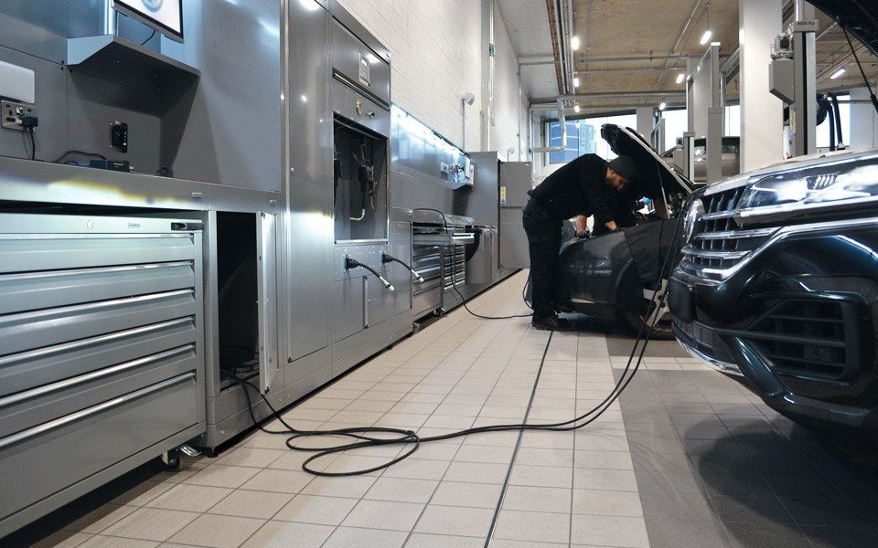 Vehicle workshop mechanic uses integrated ancillary services at fully-equipped service bays in Volkswagen’s Battersea servicing centre