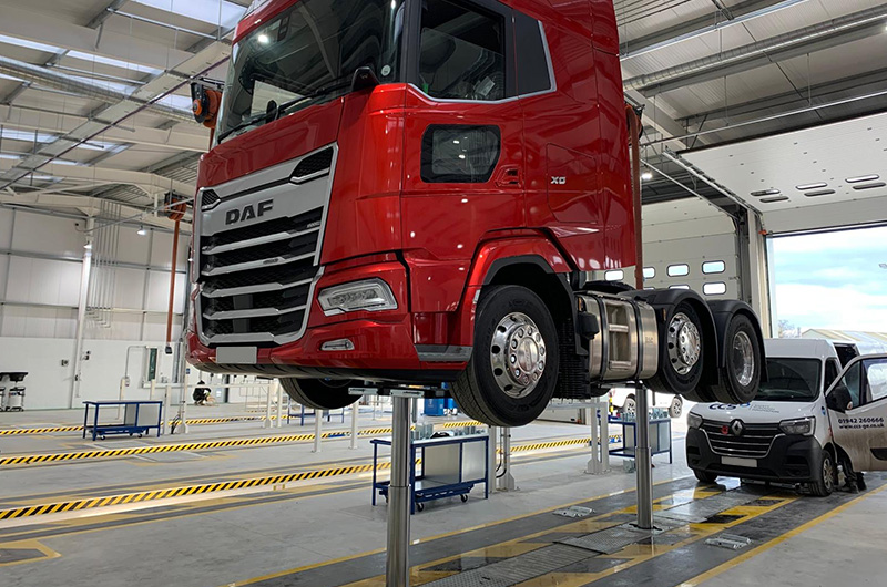 Commercial vehicle being lifted by a piston vehicle lift