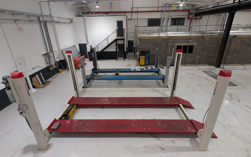 7t capacity stertil koni 4 post lift inside of commercial vehicle workshop.