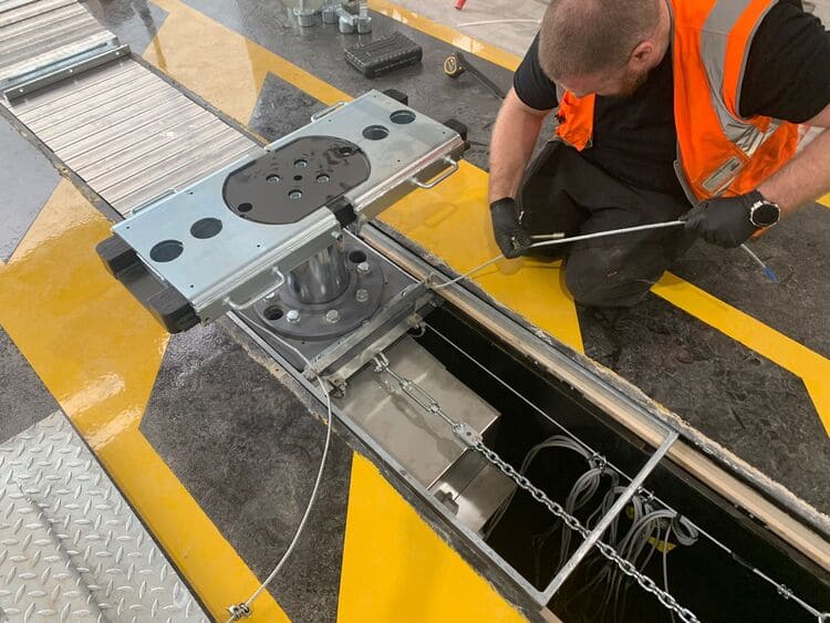 Photo shows vehicle lift with columns in place during installation process