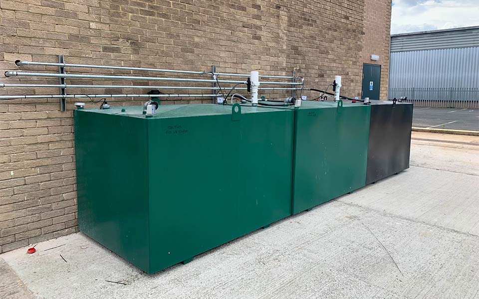 Green bunded steel storage tanks for fresh and waste oils designed and installed by CCS Garage Equipment.