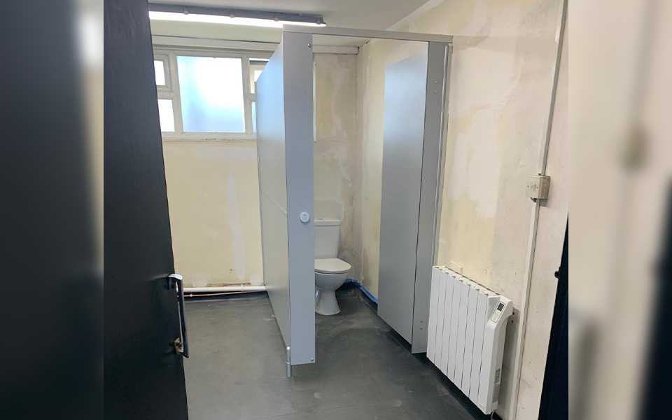 Toilet cubicles at our clients Nottingham depot mid-refurbishing featuring electric radiators.