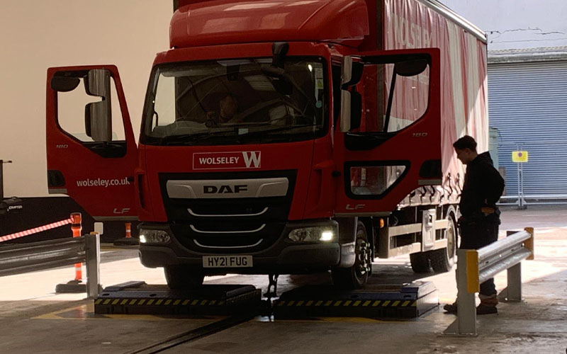 Simulated load brake testers supplied and installed by CCS undergoing testing with large red transit vehicle.