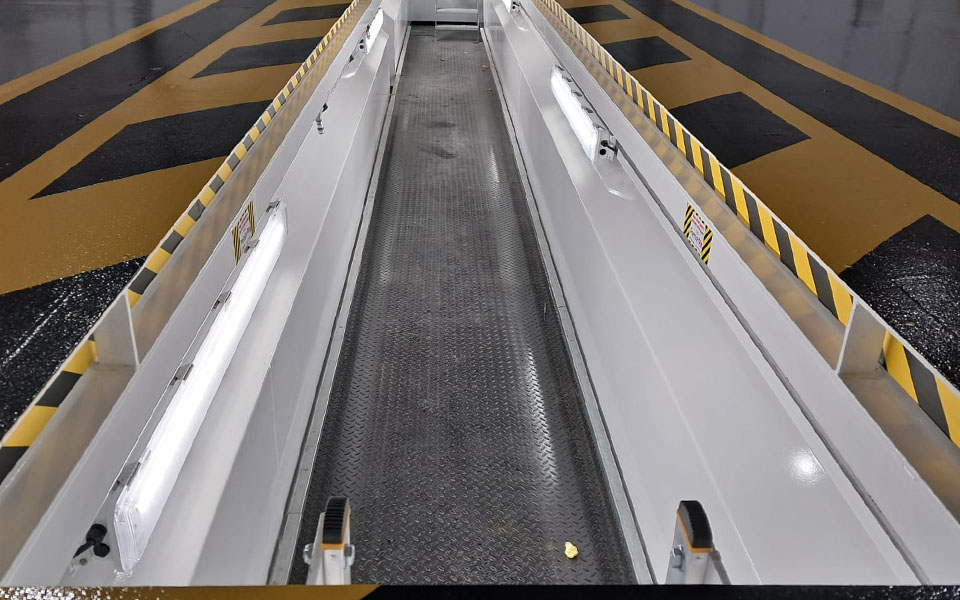 Steel inspection pits installed by CCS Garage Equipment featuring black and yellow safety floor markings.